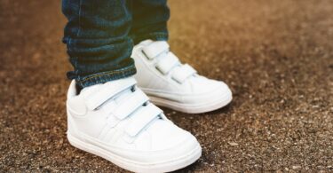 un enfant avec une paire de baskets blanches