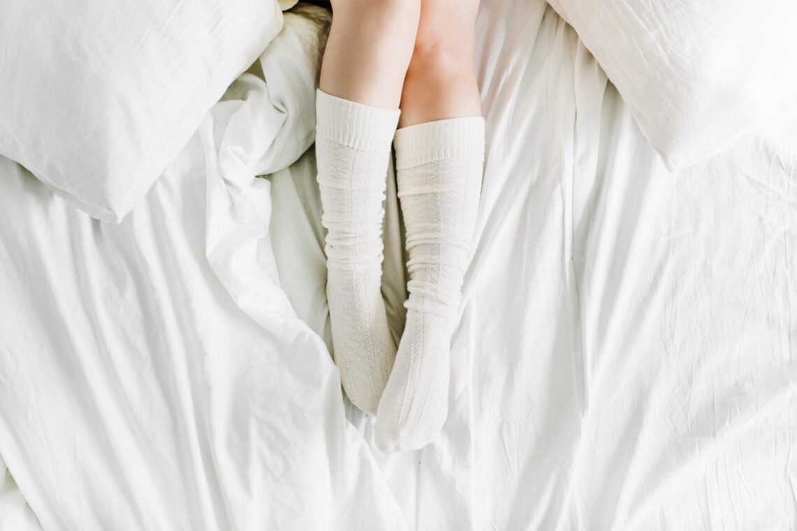 femmes sur un lit avec des chaussettes blanches