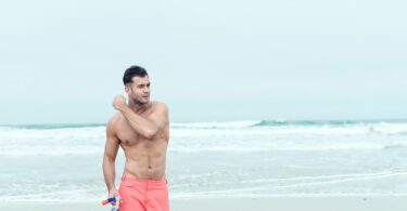 Homme à la plage en short de bain